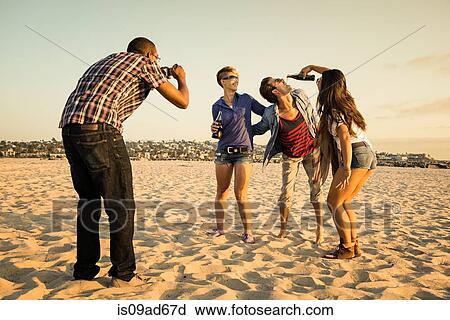 Stock Image - Man photogrpahing friends on Mission Beach, San Diego, California, USA. Fotosearch