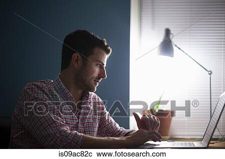 Man sitting at desk typing View Large Photo Image Stock Image - Man sitting at desk typing. Fotosearch