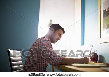 Man sitting at desk writing View Large Photo Image Stock Photography - Man sitting at desk writing. Fotosearch