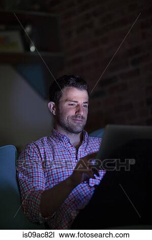 Man sitting on sofa using digital tablet View Large Photo Image Stock Image - Man sitting on sofa using digital tablet. Fotosearch