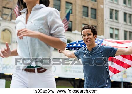 Man with American flag running after woman View Large Photo Image Stock Photo - Man with American flag running after woman. Fotosearch