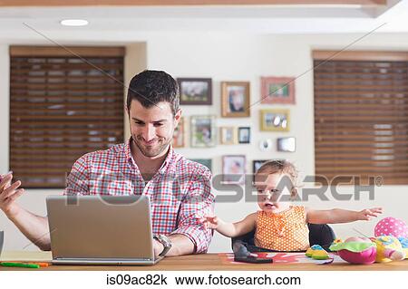 Man working at kitchen counter with baby sitting beside View Large Photo Image Stock Image - Man working at kitchen counter with baby sitting beside. Fotosearch
