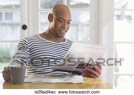Mid adult man reading newspaper View Large Photo Image Stock Image - Mid adult man reading newspaper. Fotosearch