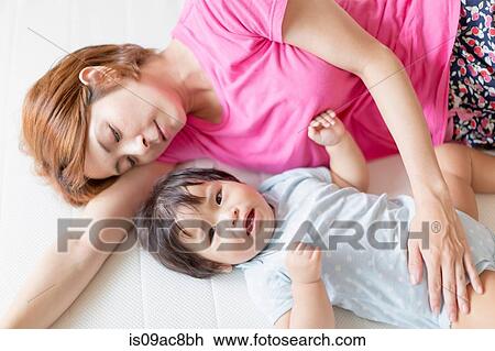 Mother and baby lying on floor View Large Photo Image Stock Image - Mother and baby lying on floor. Fotosearch