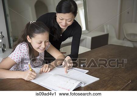 Mother helping teenage daughter with homework View Large Photo Image Stock Image - Mother helping teenage daughter with homework. Fotosearch