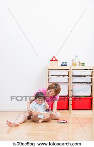 Mother reading to baby on floor View Large Photo Image Stock Image - Mother reading to baby on floor. Fotosearch