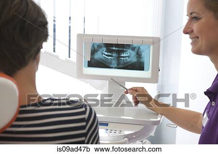 Stock Image - Patient looking at xray of dental implants. Fotosearch
