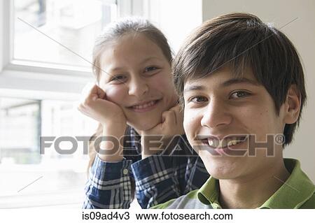 Stock Image - Portrait of brother and sister smiling. Fotosearch