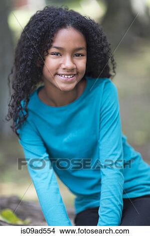 Picture - Portrait of happy young girl in park. Fotosearch