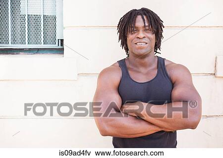 Stock Photo - Portrait of mid adult man with arms crossed. Fotosearch