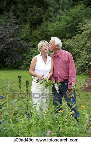 Portrait of senior couple sharing a kiss in garden View Large Photo Image Stock Photography - Portrait of senior couple sharing a kiss in garden. Fotosearch