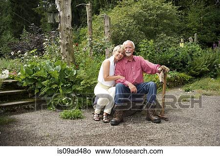 Portrait of senior couple sitting in garden View Large Photo Image Picture - Portrait of senior couple sitting in garden. Fotosearch