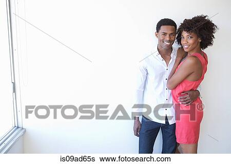 Stock Photograph - Portrait of young couple hugging. Fotosearch