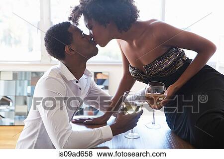 Portrait of young couple with wine, kissing View Large Photo Image Stock Photo - Portrait of young couple with wine, kissing. Fotosearch