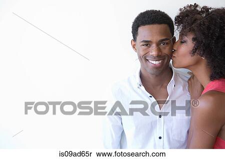 Portrait of young woman kissing man on cheek View Large Photo Image Stock Photography - Portrait of young woman kissing man on cheek. Fotosearch