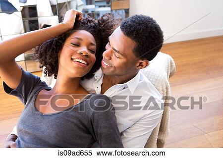 Stock Photography - Portrait of young woman sitting on man's lap. Fotosearch