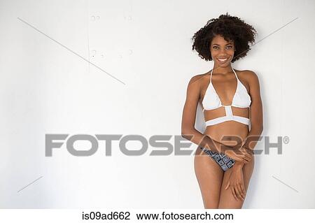Portrait of young woman wearing bikini against white background View Large Photo Image Stock Image - Portrait of young woman wearing bikini against white background. Fotosearch