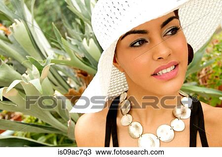 Stock Image - Portrait of young woman, wearing sun hat. Fotosearch
