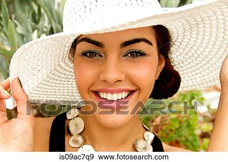 Stock Photo - Portrait of young woman, wearing sun hat. Fotosearch