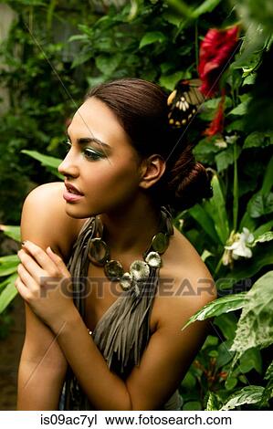 Portrait of young woman with red orchid and foliage View Large Photo Image Stock Image - Portrait of young woman with red orchid and foliage. Fotosearch