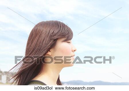 Stock Image - Profile of young woman with eyes closed. Fotosearch