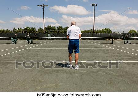 Stock Photography - Rear view of senior man on tennis court. Fotosearch