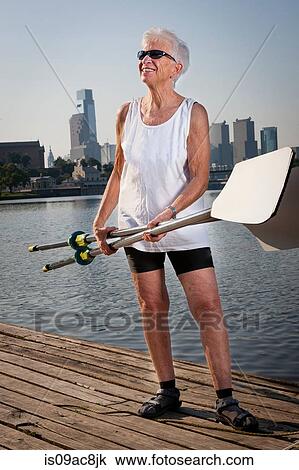 Rower on pier holding oars View Large Photo Image Stock Image - Rower on pier holding oars. Fotosearch