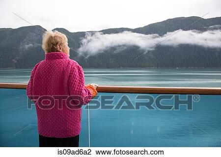 Stock Image - Senior woman on cruise ship, Alaska, USA. Fotosearch