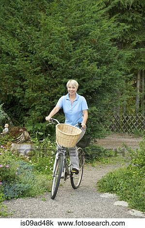 Senior woman riding bicycle in park View Large Photo Image Stock Image - Senior woman riding bicycle in park. Fotosearch