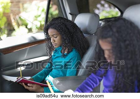 Sisters in car doing homework View Large Photo Image Stock Photograph - Sisters in car doing homework. Fotosearch