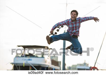 Stock Image - Skateboarder leaping for joy. Fotosearch