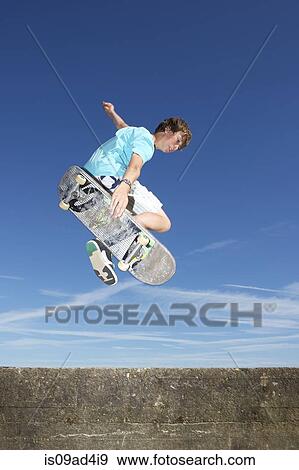 Teenage boy mid air on skateboard View Large Photo Image Stock Photo - Teenage boy mid air on skateboard. Fotosearch