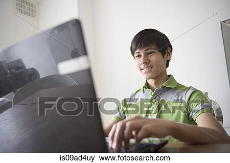 Teenage boy using laptop View Large Photo Image Stock Photo - Teenage boy using laptop. Fotosearch