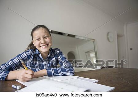 Stock Image - Teenage girl doing homework. Fotosearch