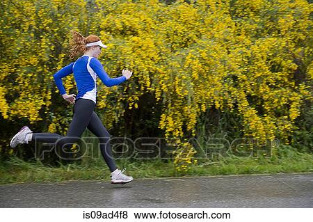 Stock Photo - Teenage girl jogging on road, Bainbridge Island, Washington, USA. Fotosearch