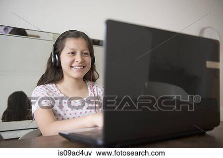 Teenage girl wearing headphones using laptop View Large Photo Image Stock Photo - Teenage girl wearing headphones using laptop. Fotosearch