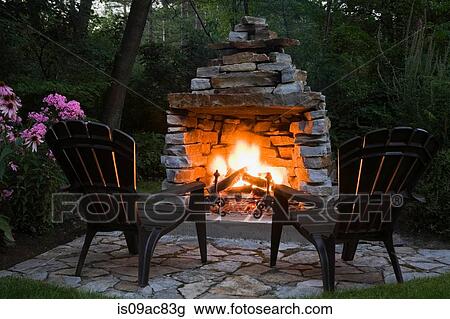 Two chairs in front of outdoor fireplace View Large Photo Image Stock Image - Two chairs in front of outdoor fireplace. Fotosearch