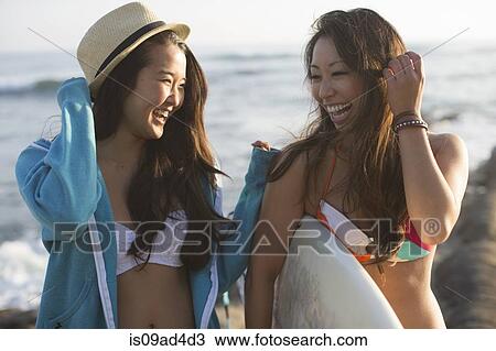 Stock Image - Two female friends with surfboard, San Diego, California, USA. Fotosearch