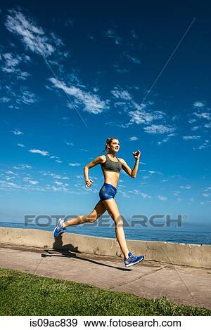 Woman running at coast View Large Photo Image Stock Photo - Woman running at coast. Fotosearch