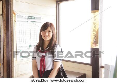 Stock Photo - Woman wearing school uniform at train station. Fotosearch