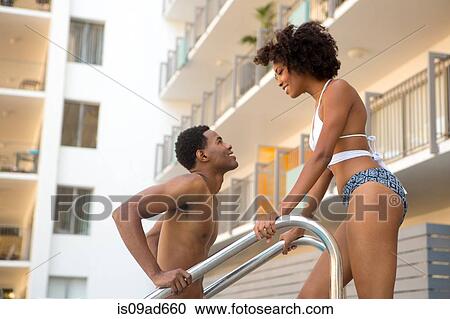 Stock Image - Young couple at poolside. Fotosearch