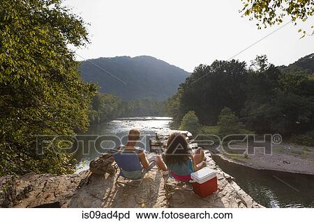 Stock Image - Young couple fishing on rock ledge, Hamburg, Pennsylvania, USA. Fotosearch