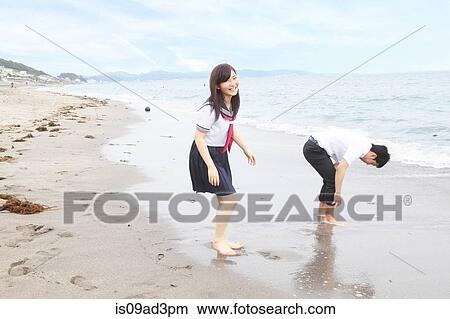Picture - Young couple fooling around on beach. Fotosearch