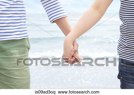 Young couple holding hands in front of sea View Large Photo Image Stock Photography - Young couple holding hands in front of sea. Fotosearch