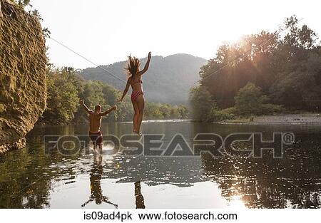 Young couple jumping into river, Hamburg, Pennsylvania, USA View Large Photo Image Stock Image - Young couple jumping into river, Hamburg, Pennsylvania, USA. Fotosearch