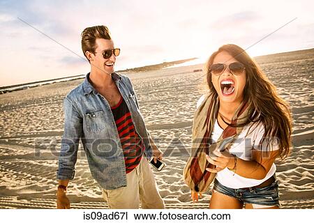 Stock Image - Young couple laughing on Mission Beach, San Diego, California, USA. Fotosearch