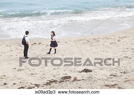 Stock Image - Young couple on sandy beach. Fotosearch