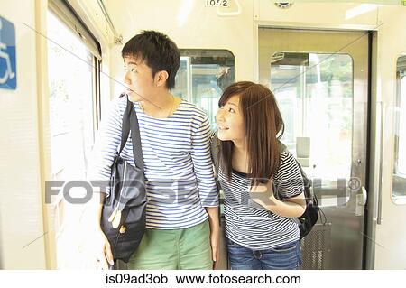 Young couple standing on train, looking through window View Large Photo Image Stock Image - Young couple standing on train, looking through window. Fotosearch