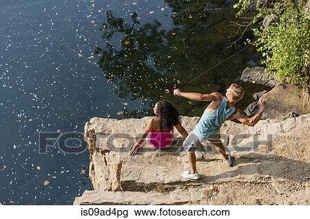 Young couple throwing stones from rock ledge, Hamburg, Pennsylvania, USA View Large Photo Image Stock Image - Young couple throwing stones from rock ledge, Hamburg, Pennsylvania, USA. Fotosearch