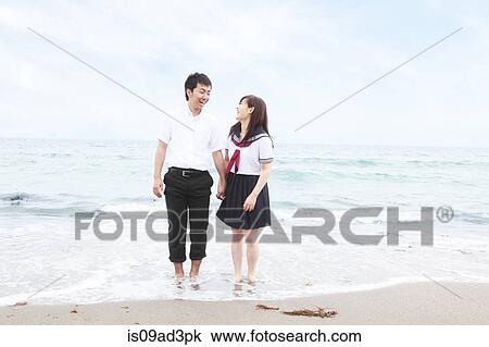Young couple wearing school uniform standing on sandy beach View Large Photo Image Stock Image - Young couple wearing school uniform standing on sandy beach. Fotosearch